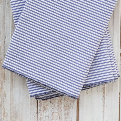 Folded blue and white striped fabric on a wooden surface